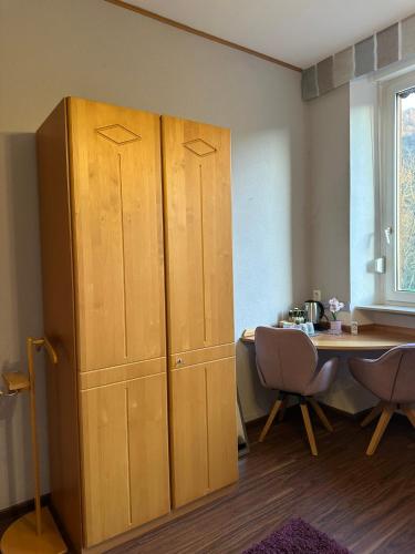 a large wooden cabinet in a room with a table at Ferienhaus Löwenherz in Pommern