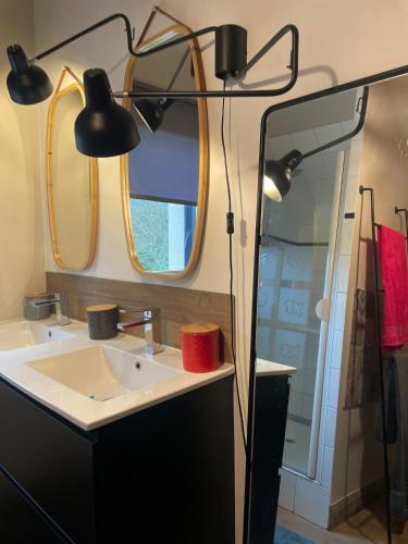 une salle de bain avec un lavabo et un miroir dans l'établissement Maison proche de la plage, à l'Île-Tudy