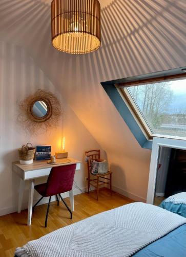 une chambre avec un lit, un bureau et une fenêtre dans l'établissement Maison proche de la plage, à l'Île-Tudy