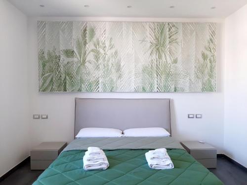 a bedroom with a green bed with a painting on the wall at Dimora Gentile Lecce B&B in Lecce