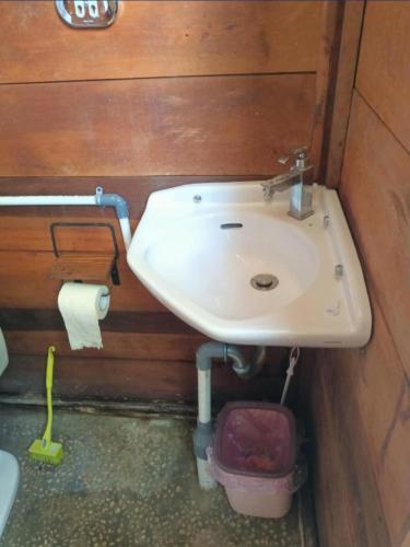 a bathroom with a white sink in a wooden wall at Lainkalogos Glamping in Rabia