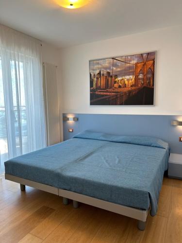 a bedroom with a bed with a blue bedspread at Sky Residence in Lignano Sabbiadoro