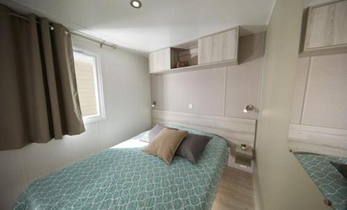 a small bedroom with a bed and a window at Mobil-home 6 pers, tout confort Clim, piscine & animations in Agde