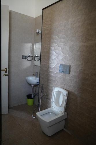 a bathroom with a toilet and a sink at Kodai Drizzle - A Luxury Villa in Kodaikānāl