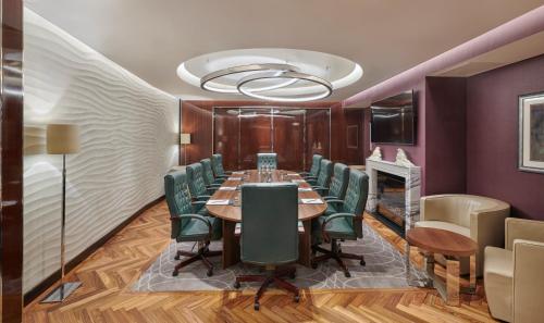 a conference room with a long table and green chairs at Hyatt Regency London Albert Embankment in London