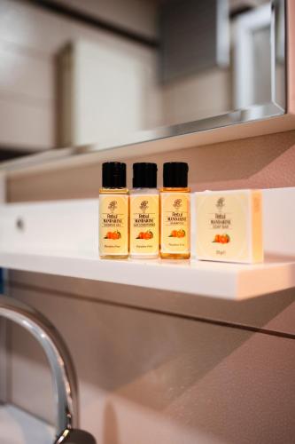 four bottles of mustard sitting on a shelf at Polek Hotel in Canakkale