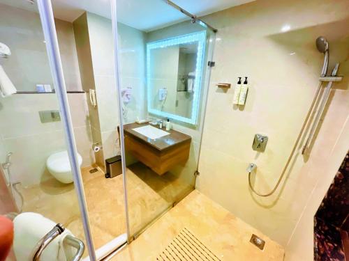 a bathroom with a glass shower and a sink at Sobit Sarovar Portico in Palolem
