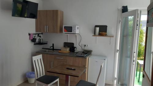 a small kitchen with a table and a microwave at LA GALLEGA in Valdoviño