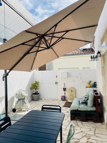 un patio avec une table et un parasol dans l'établissement Welcome Home, à La Rochelle