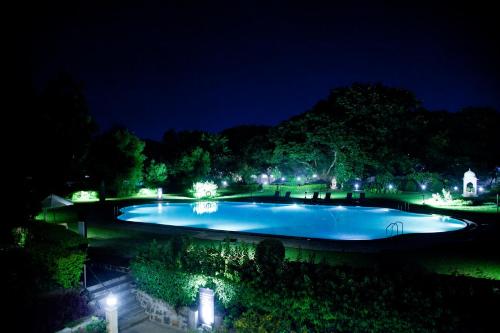 a large swimming pool at night with lights at Gateway Aurangabad - Chhatrapati Sambhaji Nagar in Aurangabad