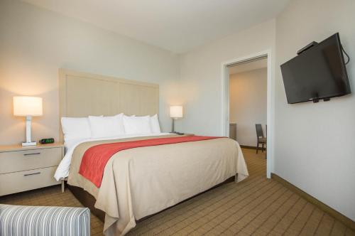 a hotel room with a bed and a flat screen tv at Comfort Inn & Suites in Campbell River