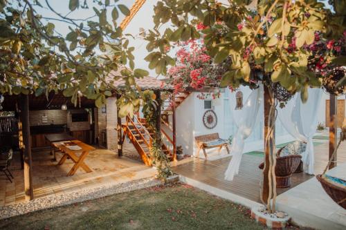 a house with a wooden deck with a tree at Vila hangloose vista da lagoa in Acaraú