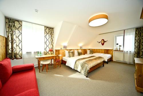 1 dormitorio con 1 cama grande y 1 sofá rojo en Illertisser Hof, en Illertissen