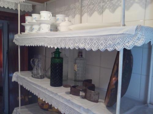 a white shelf with dishes and bottles on it at La Herreria de Esteban in Cuevas Labradas