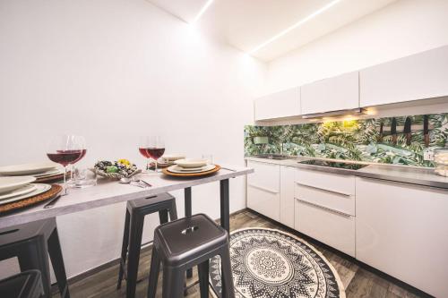 a kitchen with white cabinets and a table with glasses of wine at Luce del lago in Moltrasio