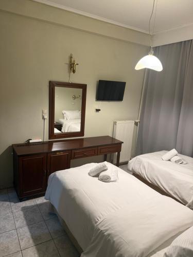 a hotel room with two beds and a mirror at ESPERIA Drama HOTEL in Drama