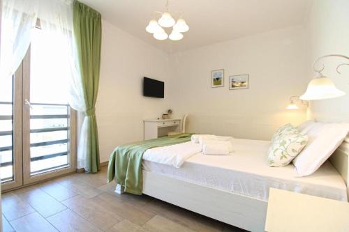 a white bedroom with a bed and a window at Elegant villa with private pool in Bale in Bale