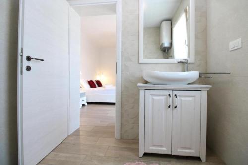 a white bathroom with a sink and a mirror at Elegant villa with private pool in Bale in Bale