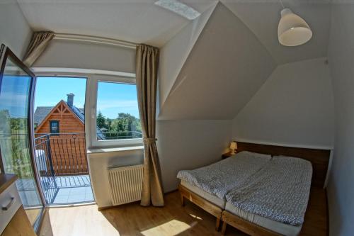 a bedroom with a bed and a large window at Pokoje i Restauracja Jantarowa in Jantar