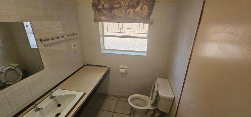 Un baño con un lavabo y un inodoro y un lavabo. en Casa Del Sol Guesthouse, en Lime Acres