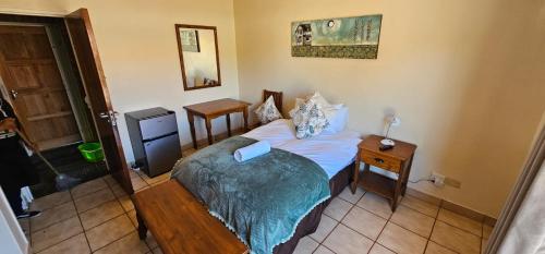 Un dormitorio pequeño con una cama y una mesita de noche. en Casa Del Sol Guesthouse, en Lime Acres