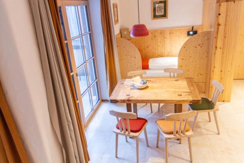 a table and chairs in a room with a table and a window at Ecologie Grundlsee in Grundlsee