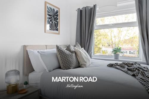 a bedroom with a large bed with a window at Vibrant and Cosy 3-Bed Home in Nottingham by Renzo, Perfect for Contractors, Free Parking! in Beeston