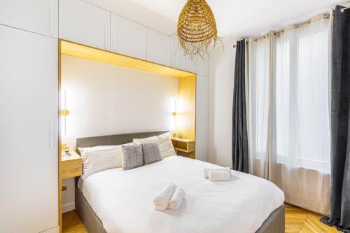 une chambre avec un grand lit avec deux serviettes dessus dans l'établissement GuestReady - Tranquil Gem, Steps from the Metro, à Paris
