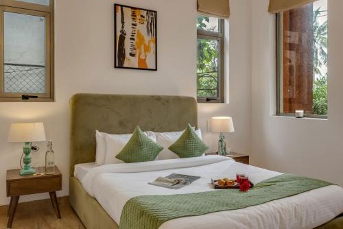 a bedroom with a bed with a tray of food on it at 4BR w Pvt Pool nr Coco Beach, Nerul in Nerul