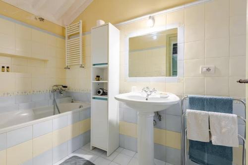 a white bathroom with a sink and a bath tub at Typical Tuscan home in the village of Cetona in Cetona