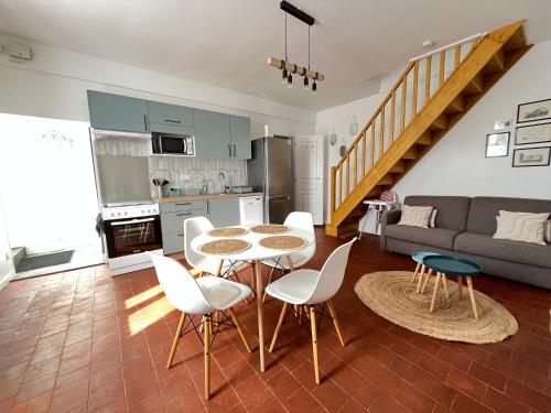 une cuisine et un salon avec une table et des chaises dans l'établissement Gîte cosy tout confort - Le palmier, à Chailles