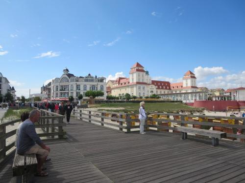 a man sitting on a bench on a boardwalk at RügenHerz DACHTRÄUME Atelierwohnung 1 - 4 Personen in Parchtitz