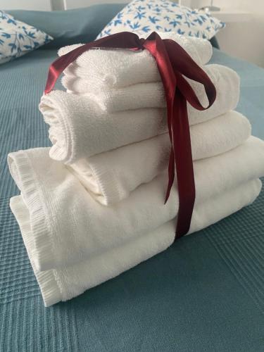 a stack of towels with a red ribbon on a bed at il posto giusto - the right place in Anzio