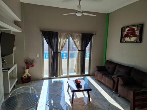 a living room with a couch and a table at Departamentos La roca D2 in La Peñita de Jaltemba