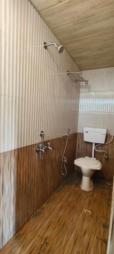 a bathroom with a toilet and a shower at Hiral valley view residency in Matheran