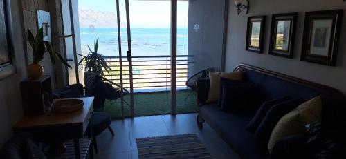 a living room with a blue couch and a view of the ocean at 210 at Beach in Strand