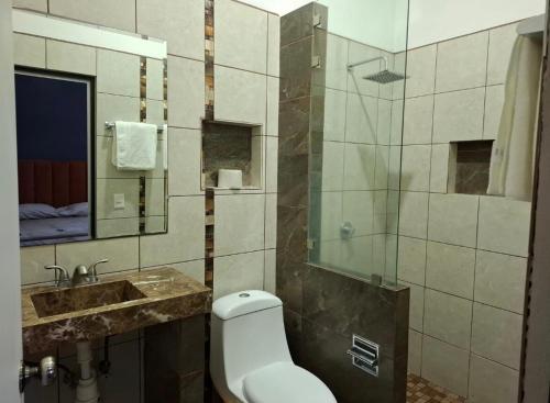 ein Badezimmer mit Toilette, Waschbecken und Dusche in der Unterkunft Departamentos La roca D2 in La Peñita de Jaltemba