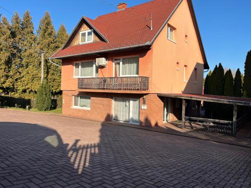 a large brick building with a balcony on a street at Gyógygödör Vendégház in Szekszárd