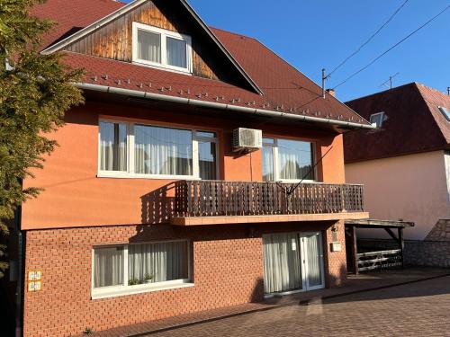a red brick house with a balcony on it at Gyógygödör Vendégház in Szekszárd