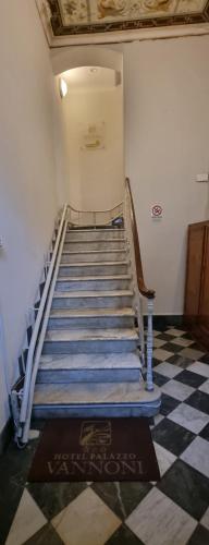 a staircase in a building with blue stairs and a checkered floor at Hotel Palazzo Vannoni in Levanto