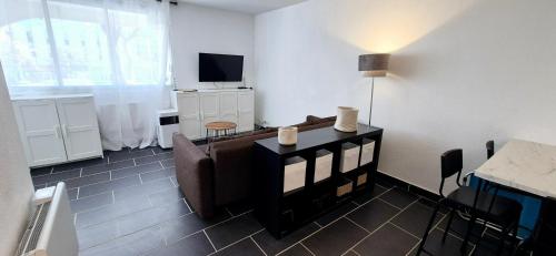 un salon avec un canapé et une télévision dans l'établissement L'Échappée Bleue, cosy design 2mn mer, au coeur du centre ville, à La Grande Motte