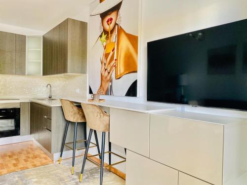 a kitchen with a large tv on the wall at Canaryislandshost l Boya Suites in Playa Honda