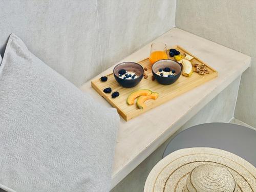 a tray of fruit and juice on a table at Canaryislandshost l Boya Suites in Playa Honda