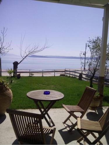 a table and two chairs and a table with a view of the ocean at Evoikos beach & resort in Livanátai