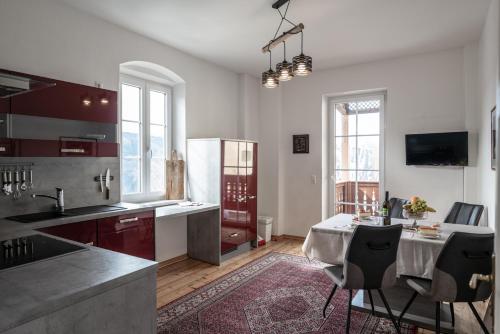a kitchen with a table and some chairs in it at Domitian 2 in Millstatt