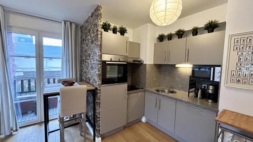 a kitchen with white cabinets and a large window at La Villa Saint Germain in Saint-Valery-sur-Somme