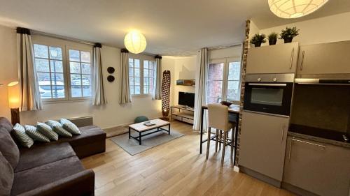 a living room with a couch and a kitchen at La Villa Saint Germain in Saint-Valery-sur-Somme