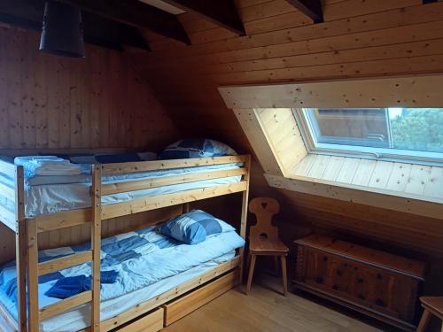 a bedroom with two bunk beds in a cabin at Chalet au cœur de la station in Thollon