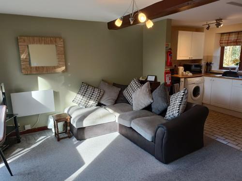 a living room with a couch and a kitchen at The Grove Cromer in Cromer