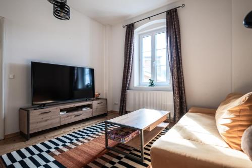 a living room with a flat screen tv and a couch at Domitian 2 in Millstatt